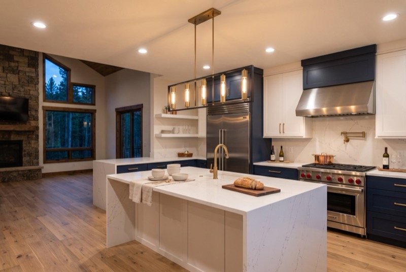 Kitchen lit by brass pendant fixtures and recessed ceiling lights